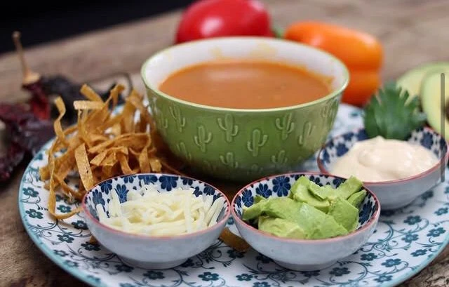 Chilaquiles con salsa, crema, queso y tortilla crocante.