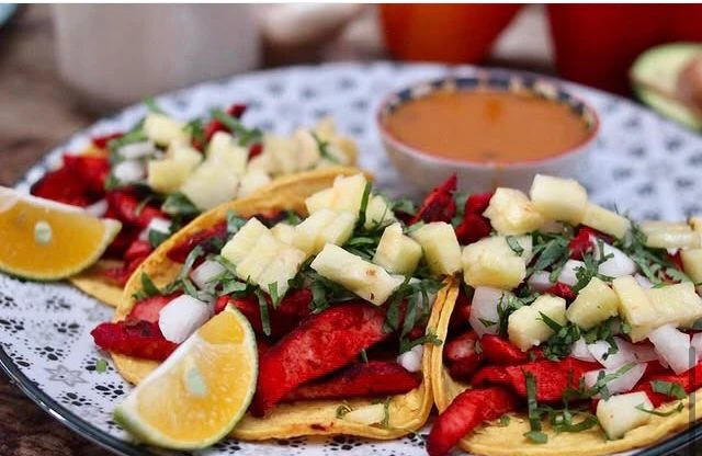 Tacos de birria dorados con su consomé aparte.